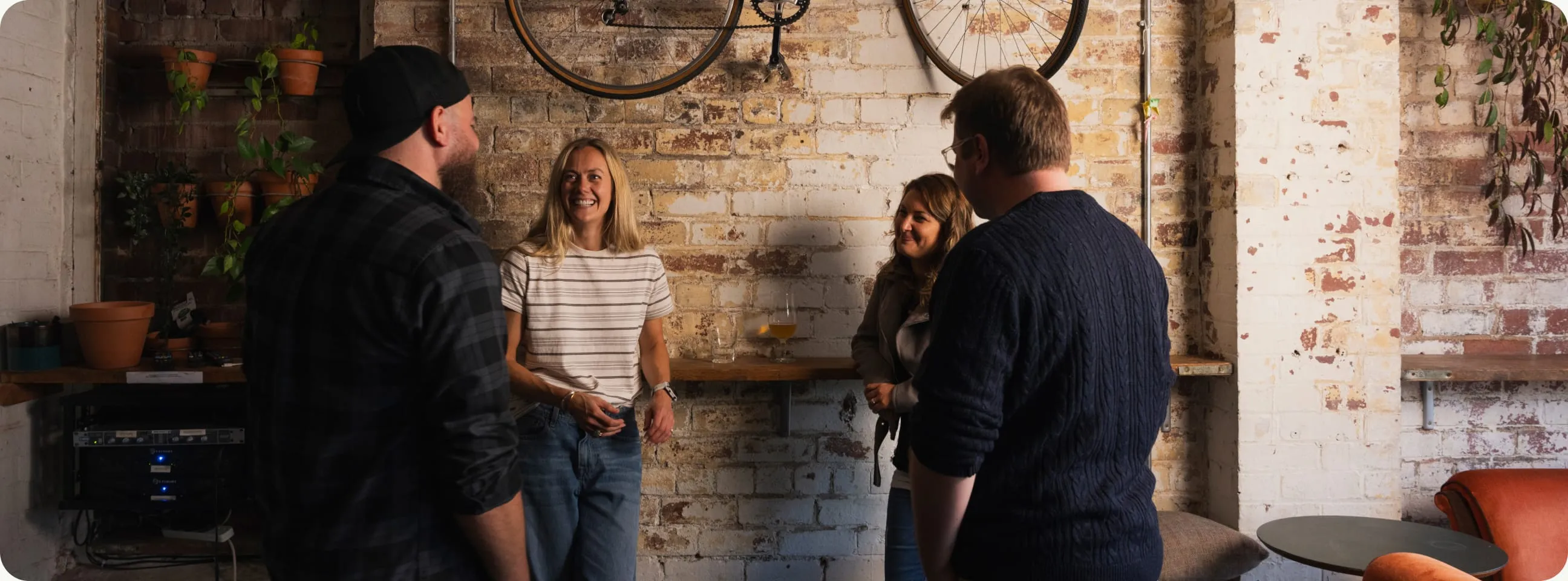 The team chatting by the brick wall in the studio