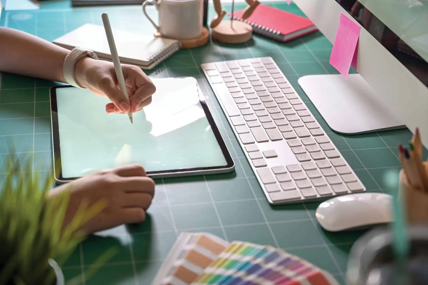 A designer at a desk with colour swatches and a keyboard