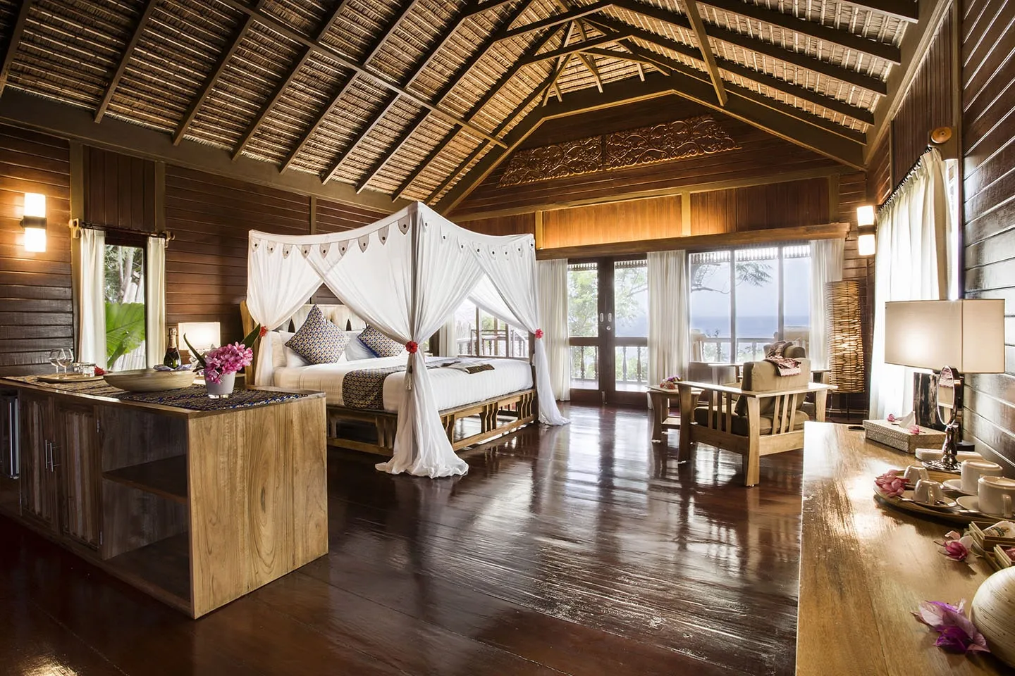 A Bunaken Oasis villa with a four-poster bed and wooden floors