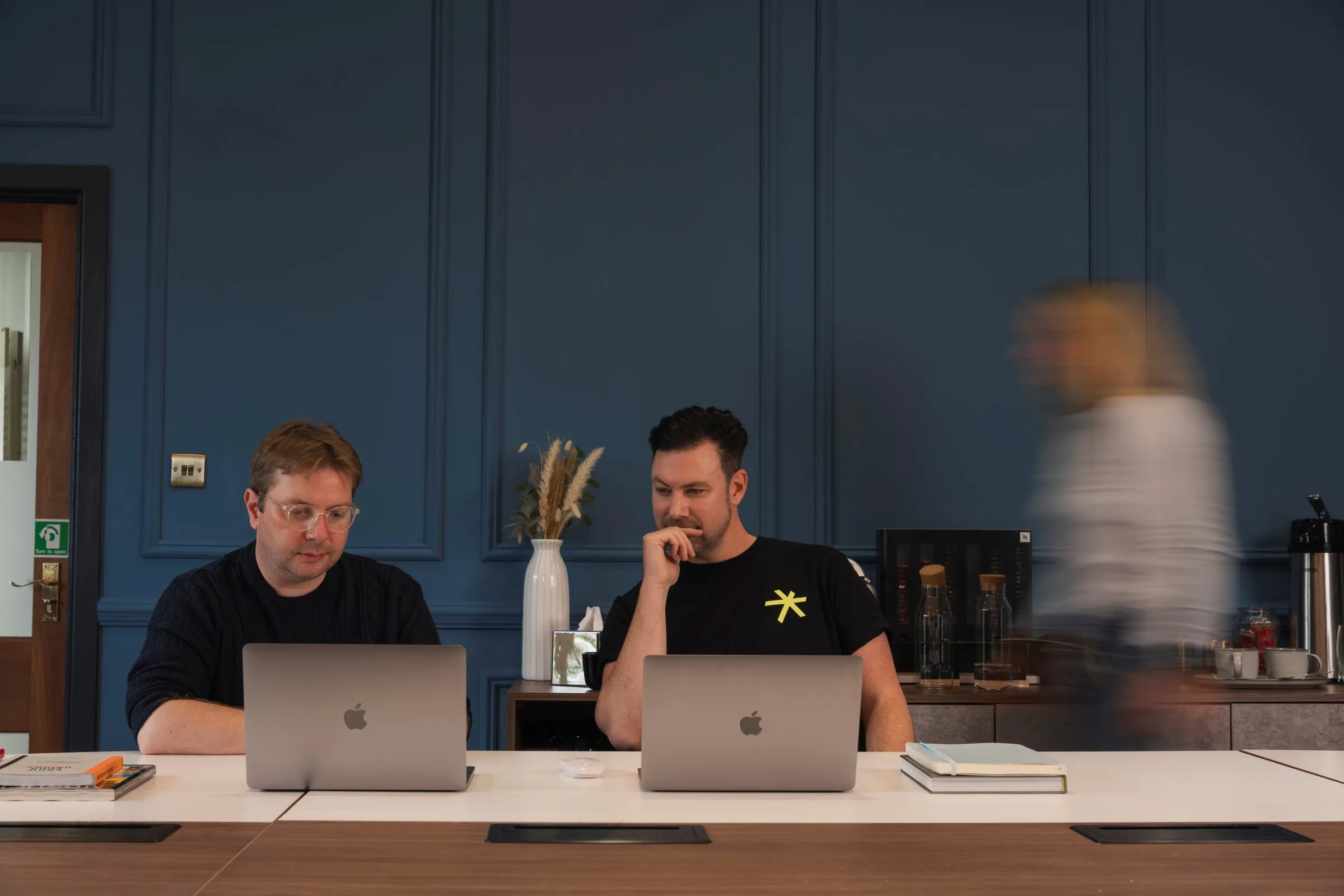 Two of the team at work on laptops