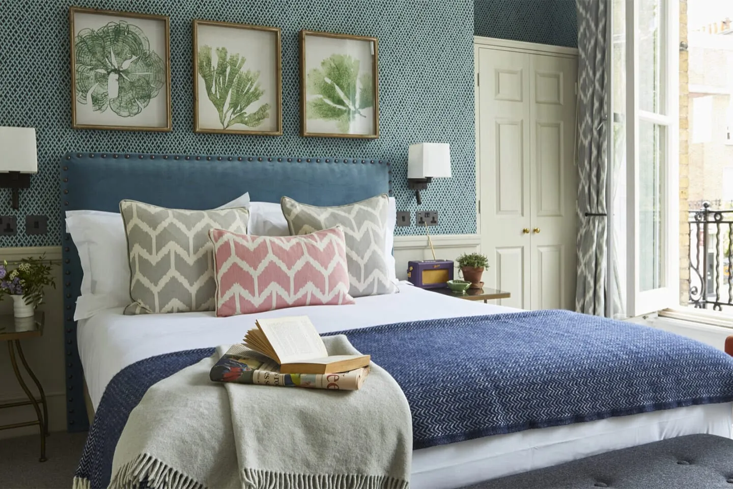 A bedroom at the Lime Tree Hotel with a blue headboard and patterned cushions