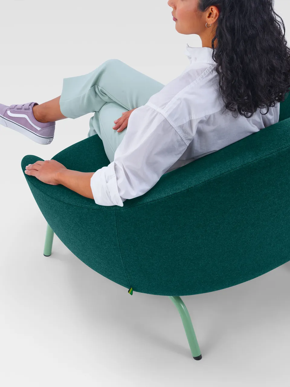 A woman in a green NaughtOne armchair
