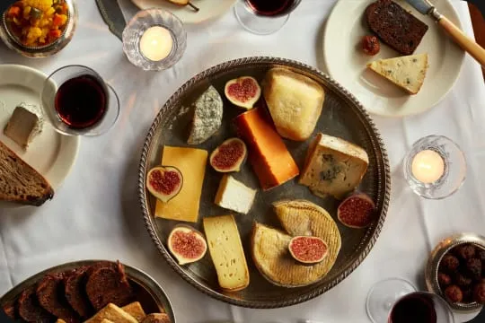 A sharing board of cheese, fruit and bread on a pub table