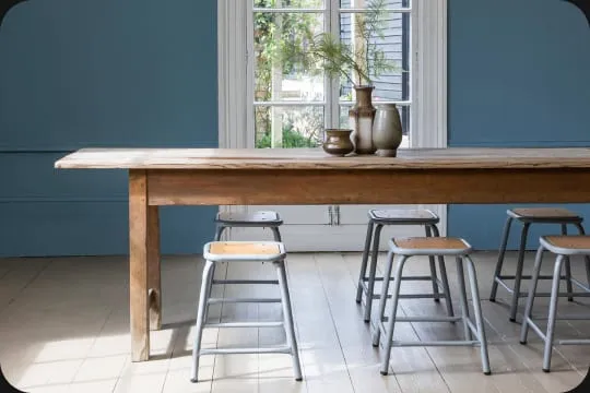 A Merchant & Found table and chairs in a bright room with blue walls