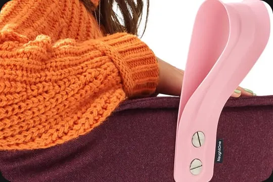 A person in an orange jumper beside a pink NaughtOne chair