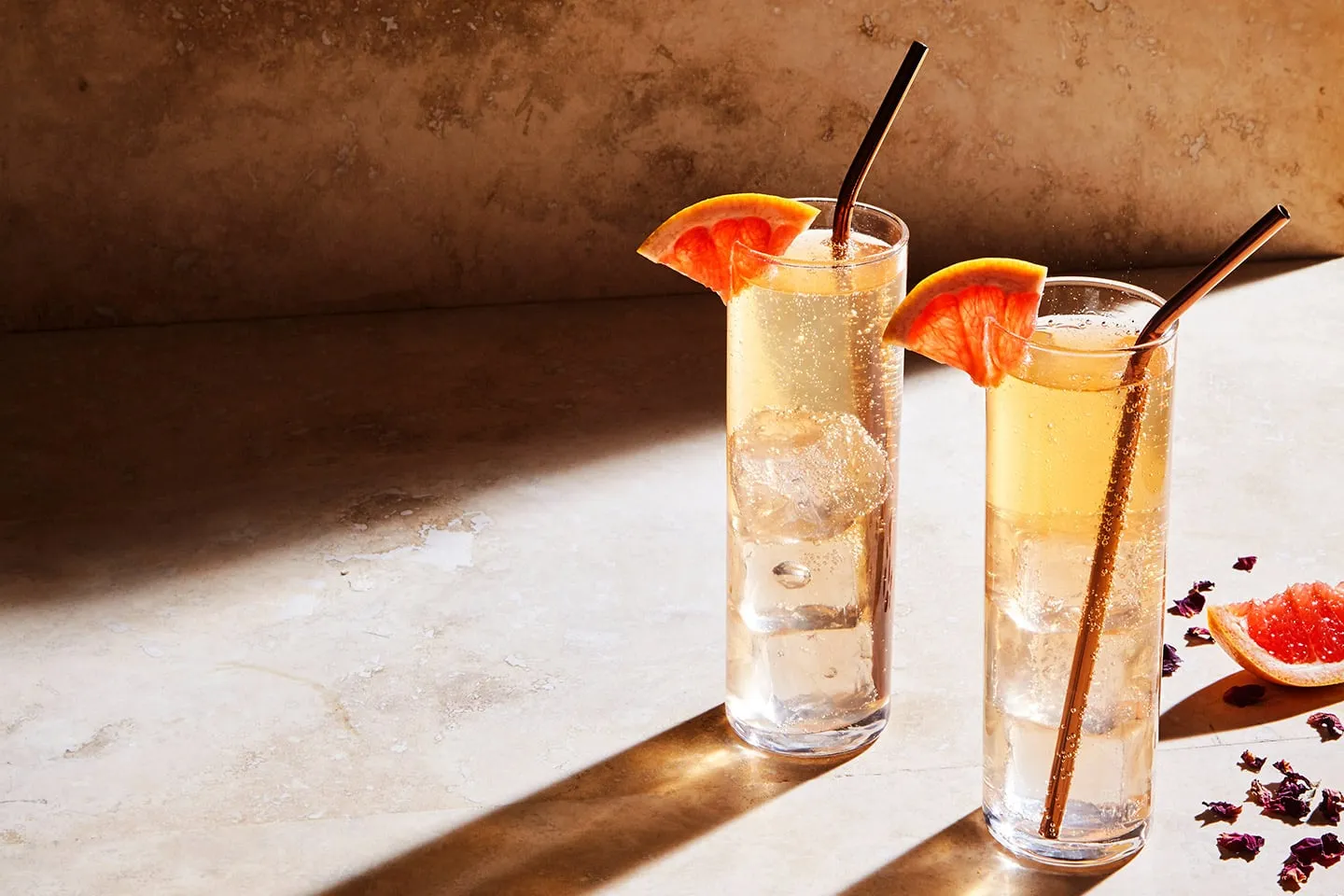 Two Tenjaku highballs with grapefruit on a stone table