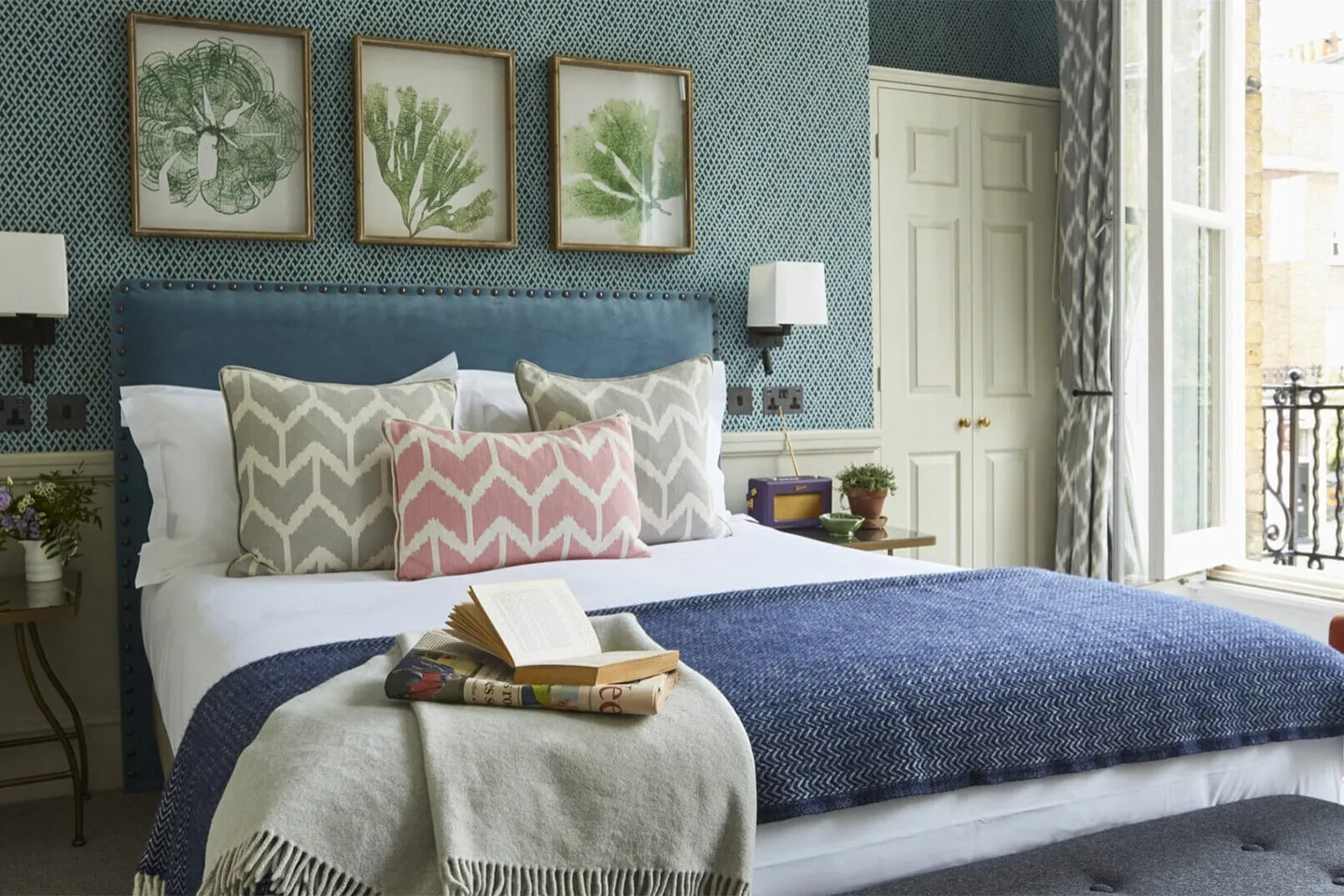 A Lime Tree Hotel bedroom with patterned cushions and a book on the bed