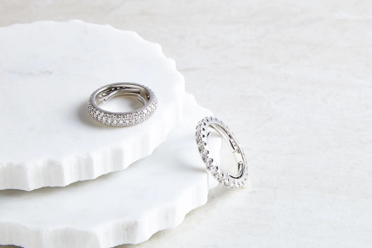 Two diamond rings on white marble