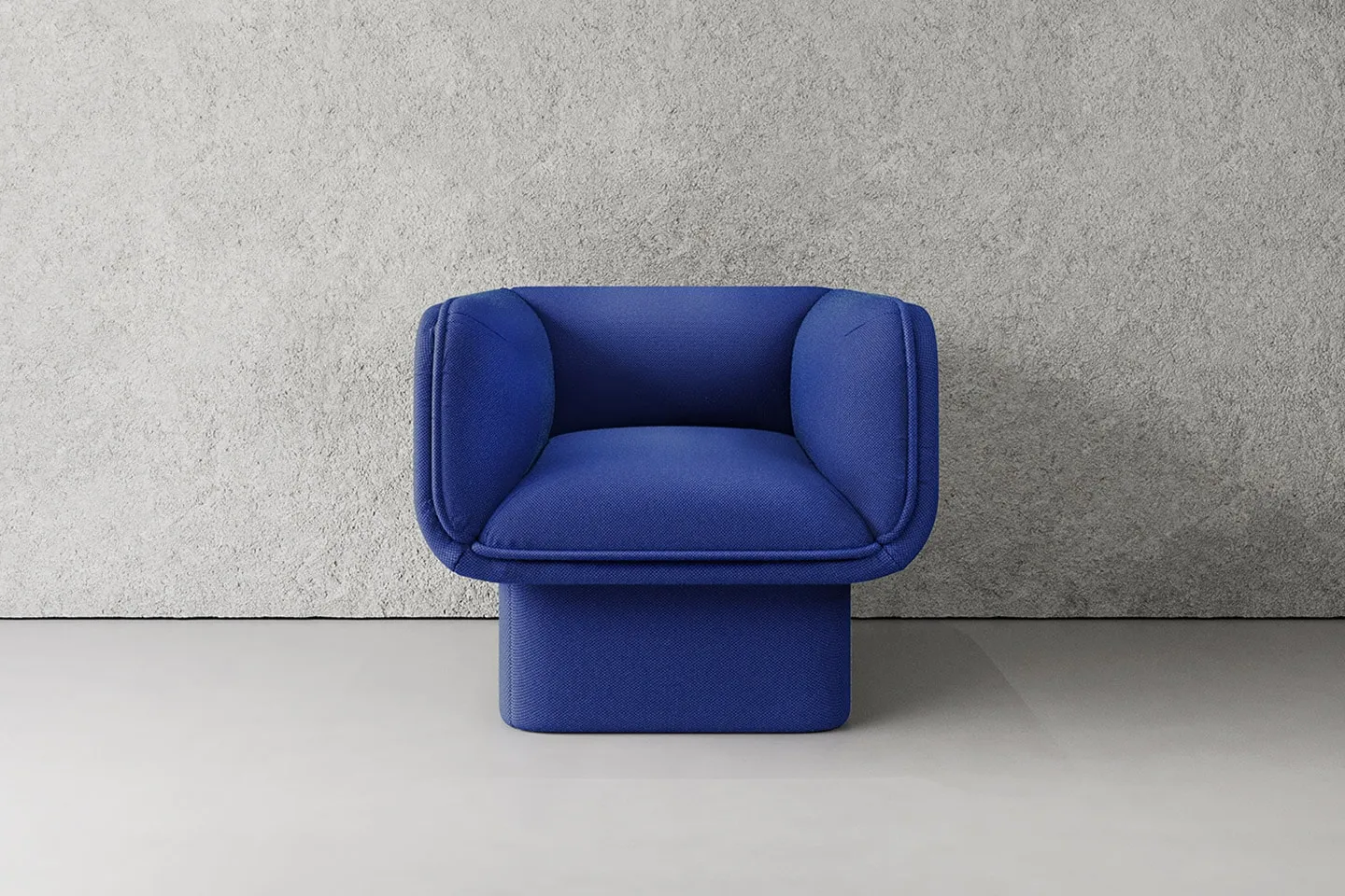 A blue upholstered armchair against a pale wall