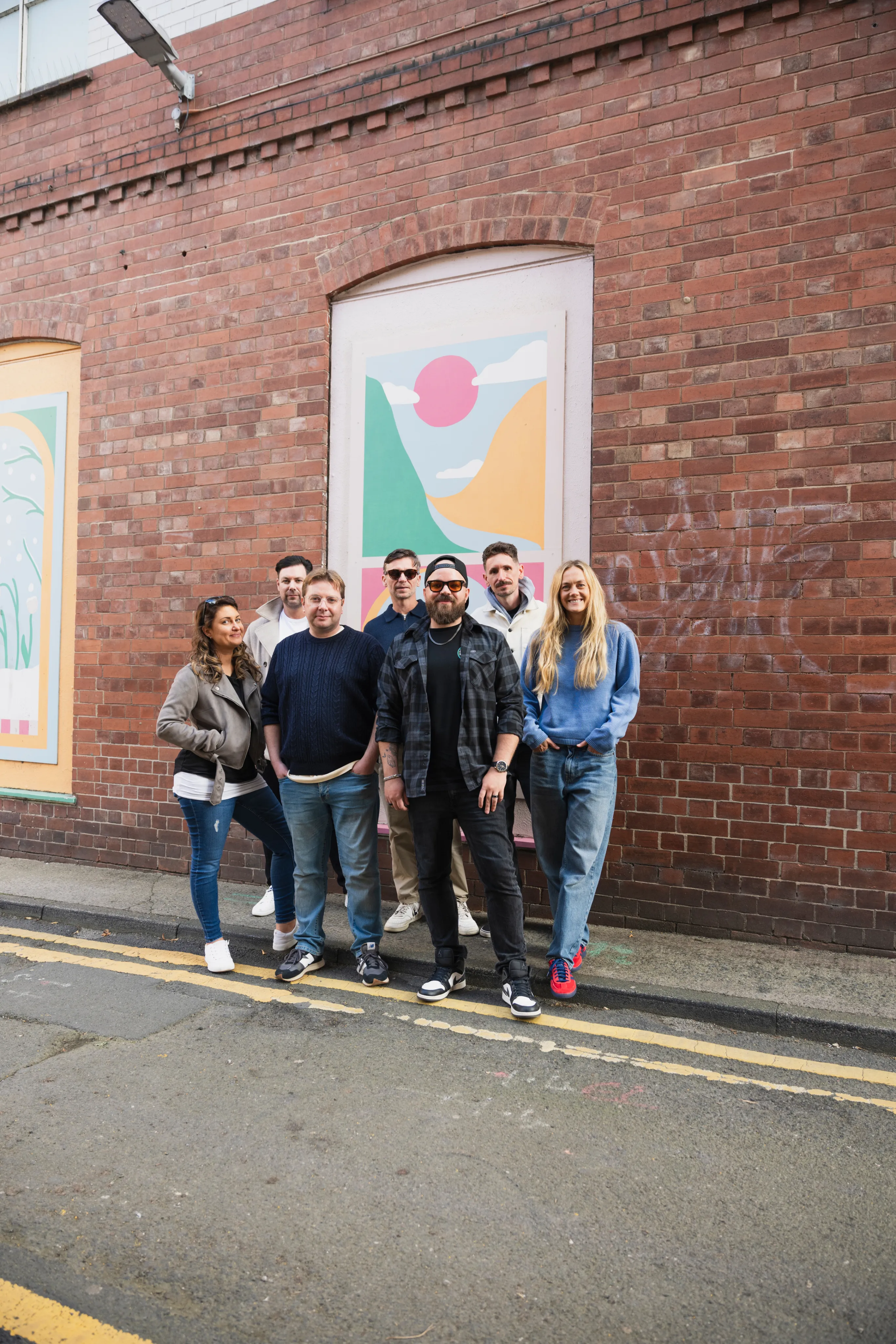 The Adigi team in front of a mural